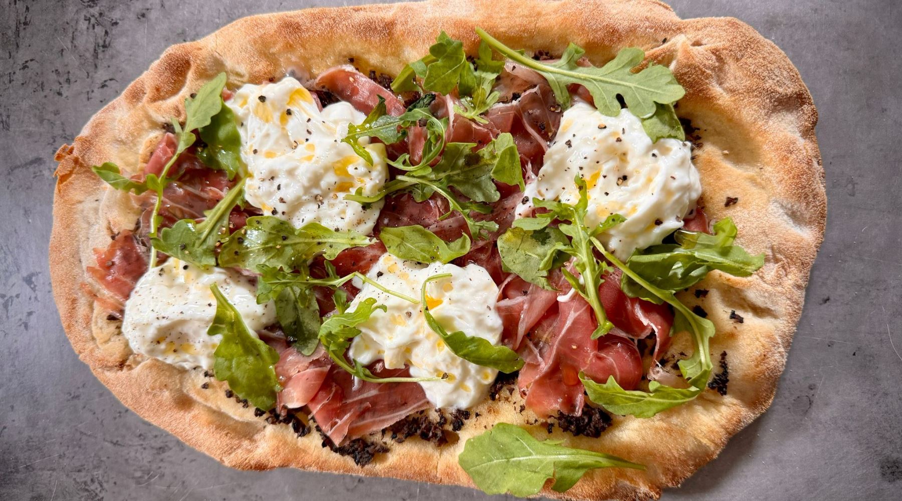 Pinsa Romana with stracciatella, prosciutto di Parma and truffle sauce