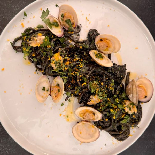 Spaghetti with squid ink, clams, bottarga and lemon oil